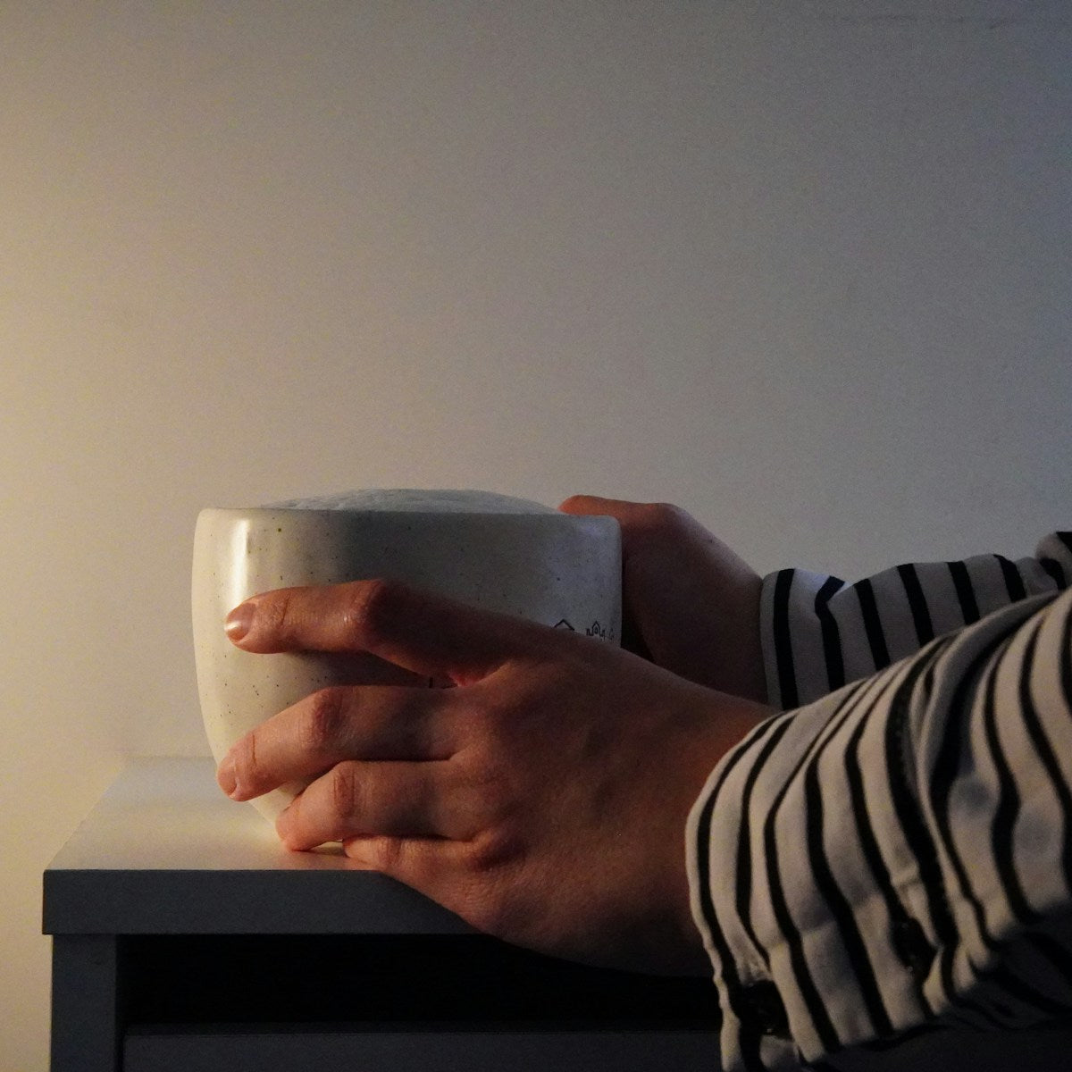 Hands holding a warm mug, everyday self-care
